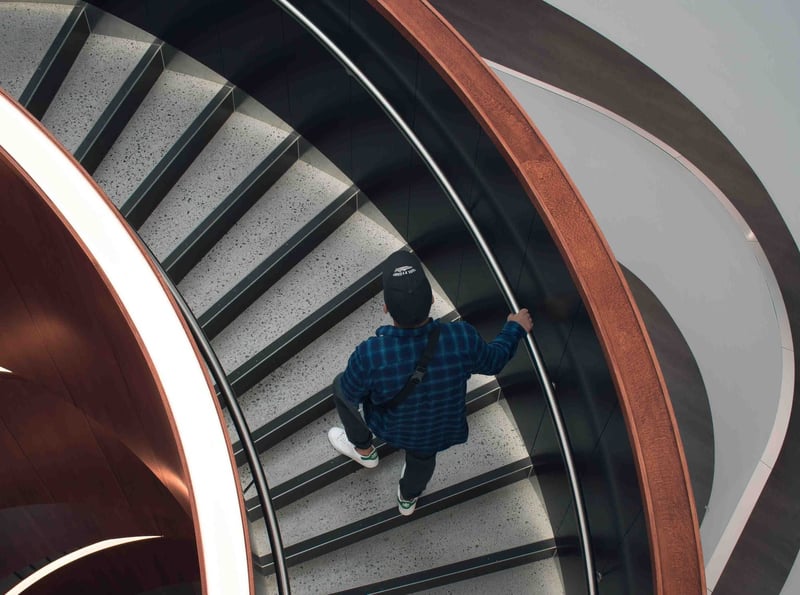 A person climbing up a spiral staircase.