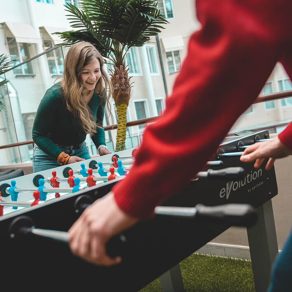 Two young professionals are playing table football at twoday's office.