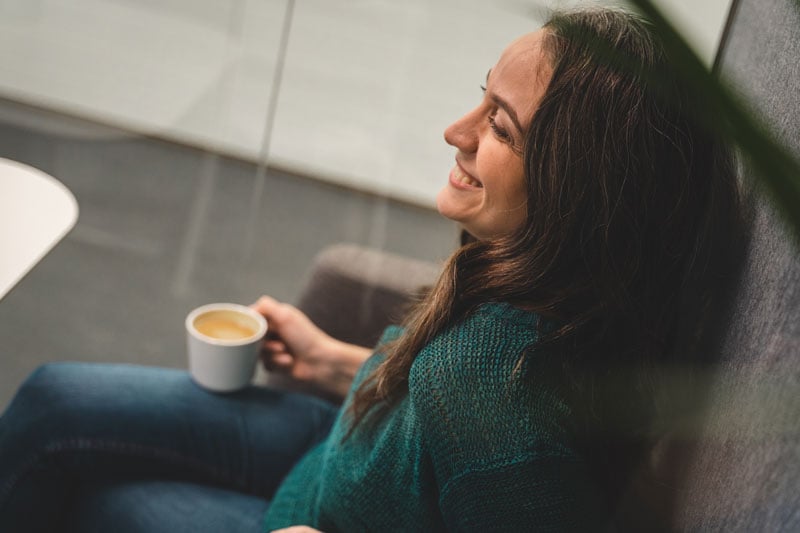 An professional enjoying a break with a cup of coffee in hand.