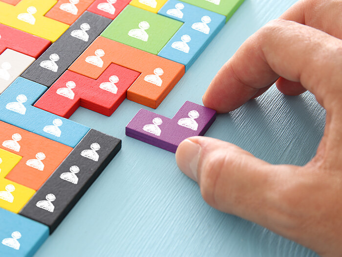 A hand that is putting the last piece of the puzzle into place.