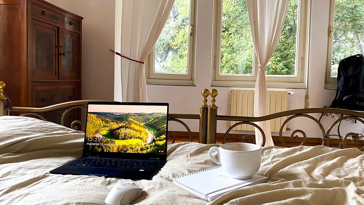Kannettava tietokone hotellihuoneessa sängyn päällä