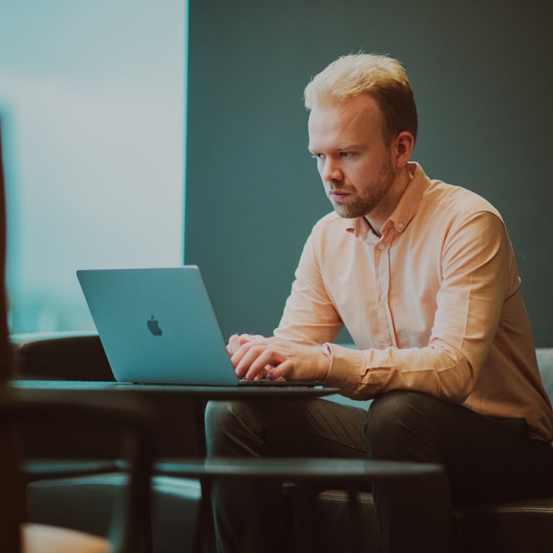 Bilde av en ung mann som sitter og jobber på en PC