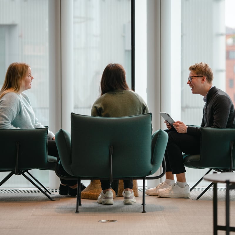 Bilde av tre mennesker bakfra som sitter i en sittegruppe